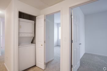 A white refrigerator is in a kitchen with a white door.